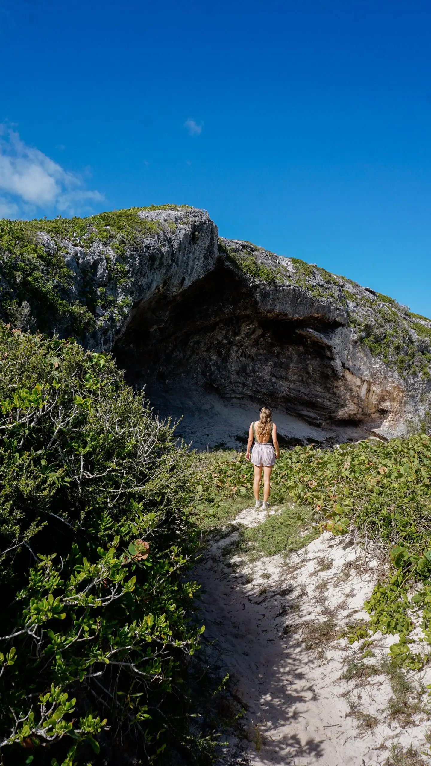 Explorer standing at the mouth of a limestone cave on Middle Caicos